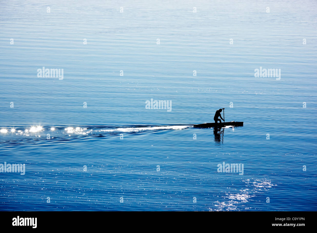 silhouette of canoe rower on lake Stock Photo