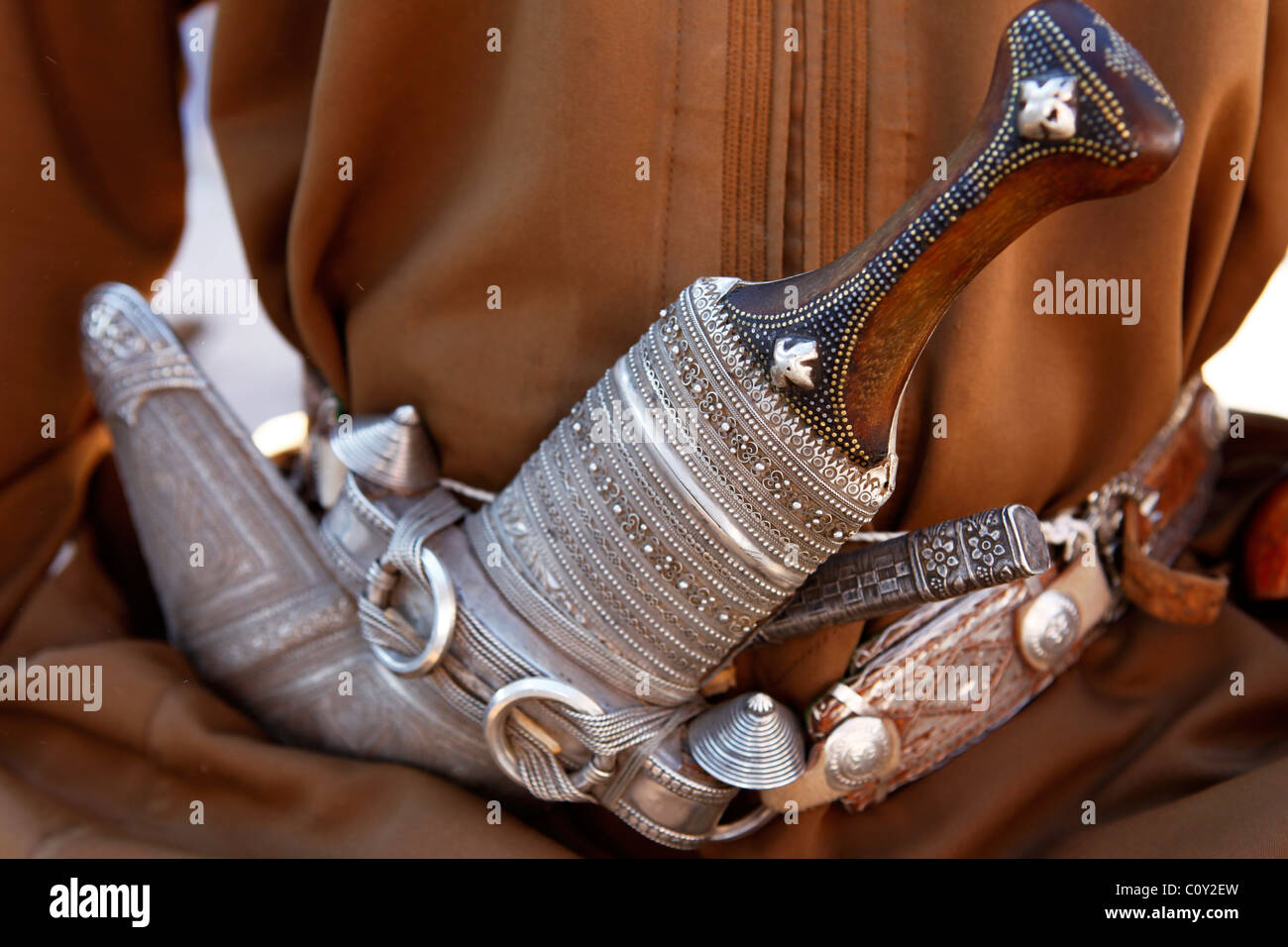 A man wears an ornate silver Khanjar dagger in his belt in Oman. Stock Photo