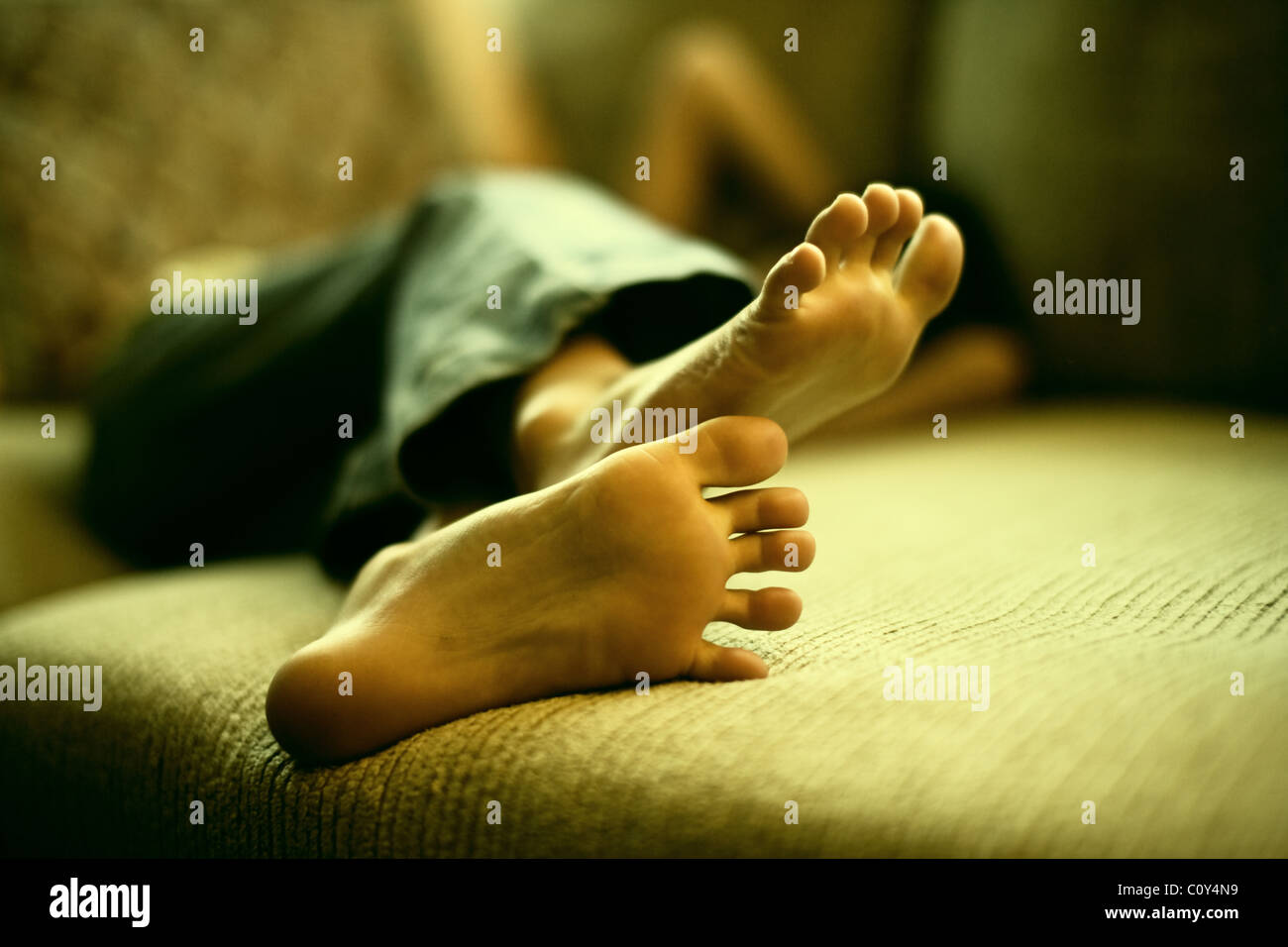Girl's feet as she relaxes on sofa Stock Photo Alamy