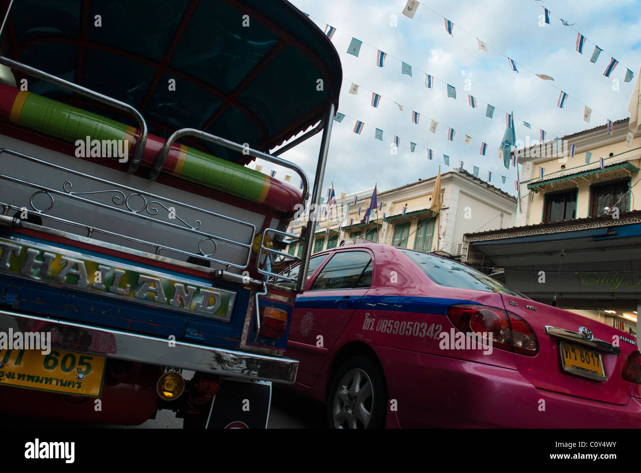 back of Tuk Tuk autorickshaw  and a pink taxi Bangkok Thailand Stock Photo