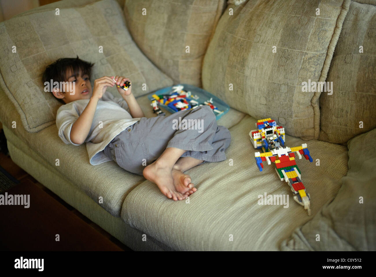 Boy with plastic block space ship of his own design Stock Photo