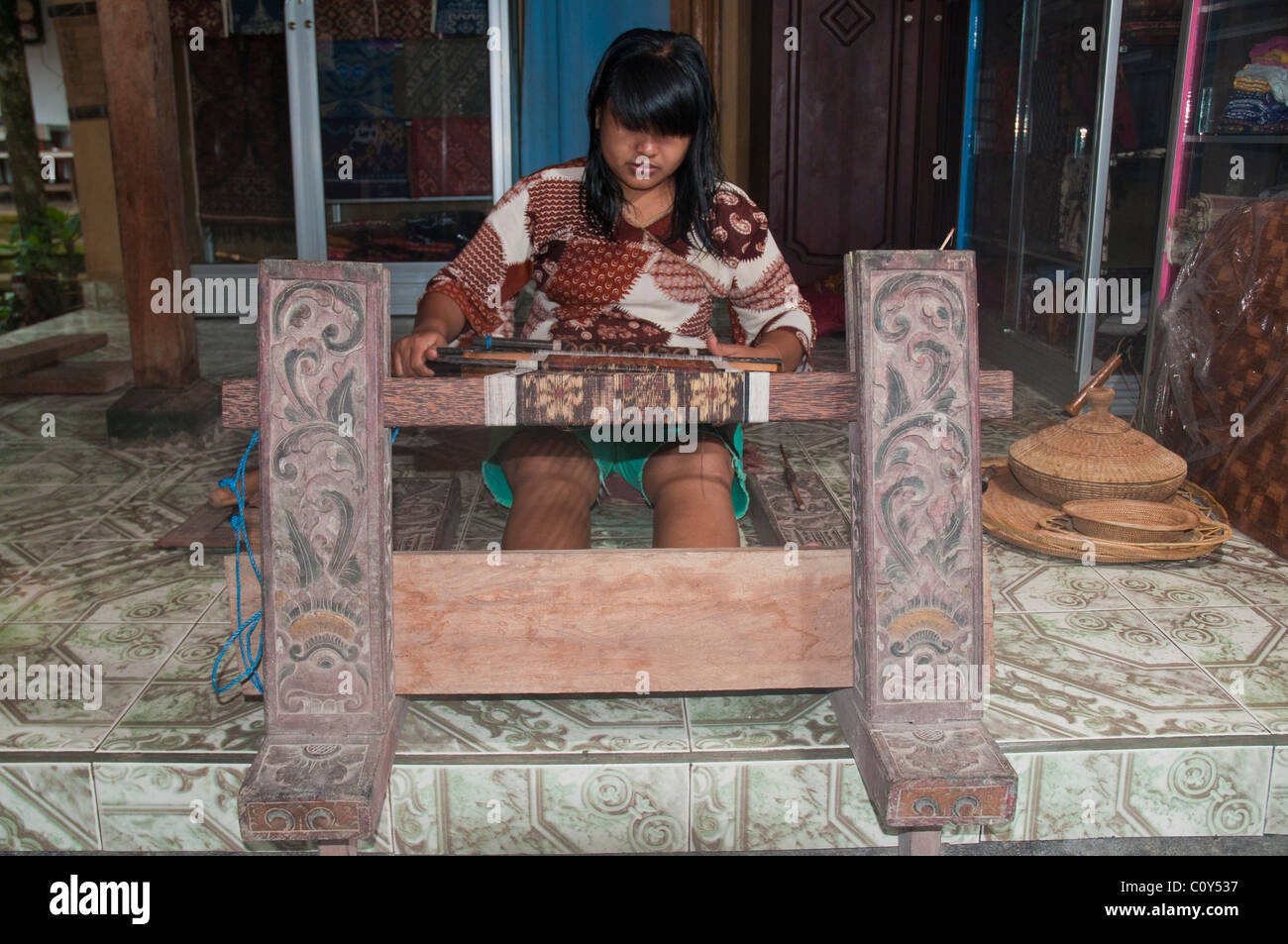 Woman doing traditional ikat weaving in the aboriginal Aga village of Tenganan in eastern Bali Stock Photo