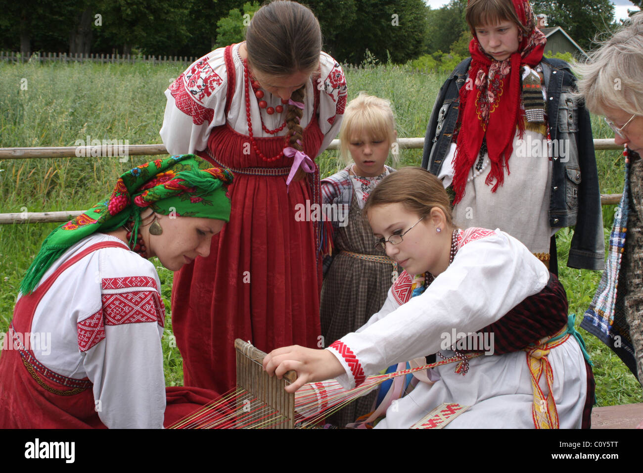 Girl, teaching traditional weaving at folklore festival in Pskov region. Russia Stock Photo