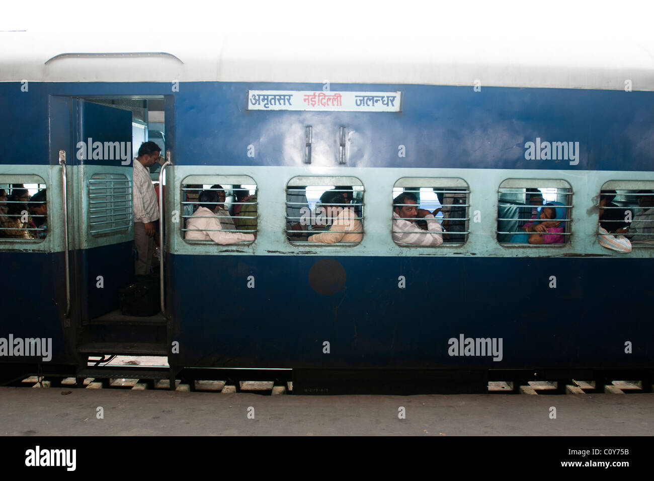People waiting for a train departure in New Delhi train Station Stock Photo