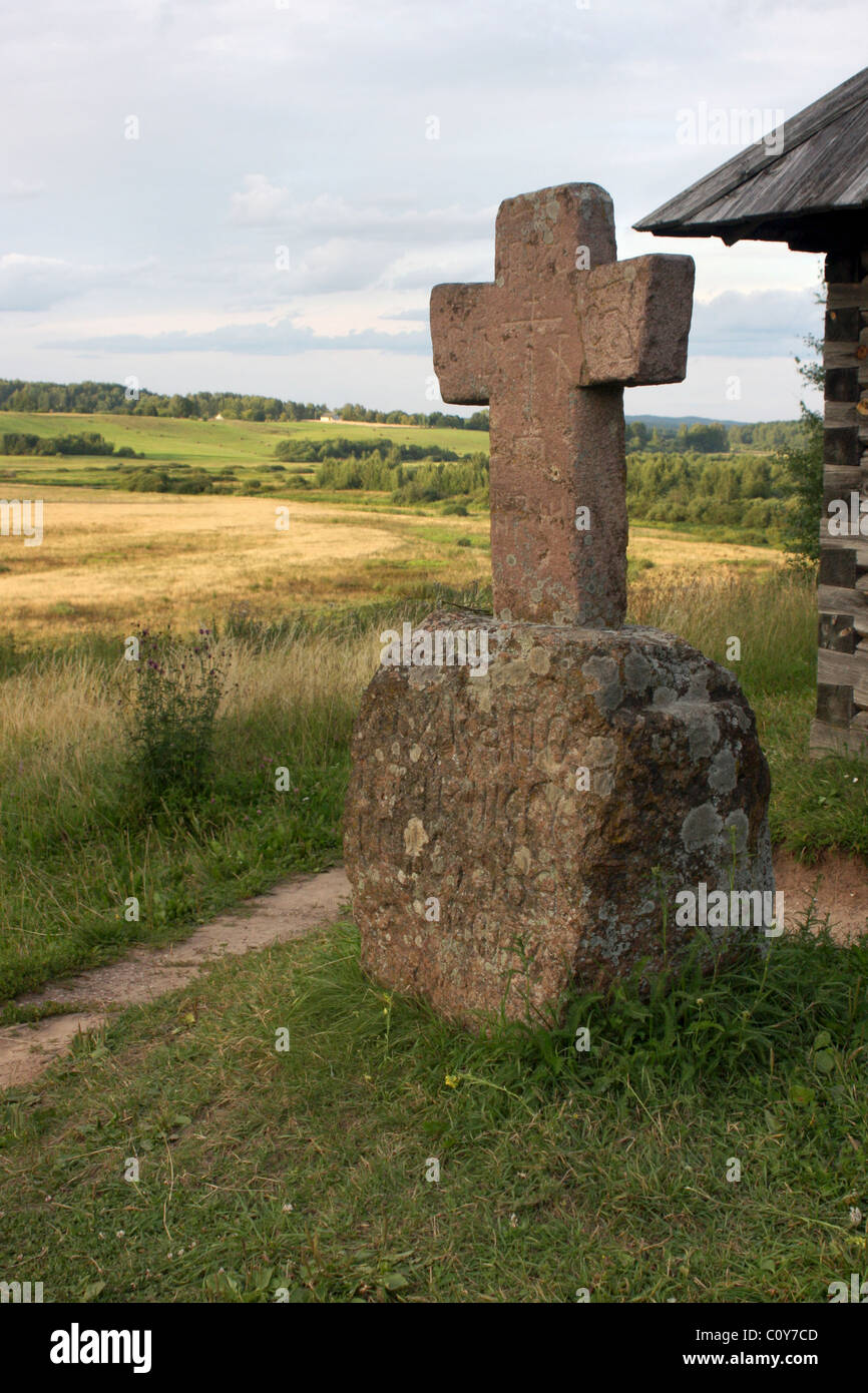 Picturesque valley with a memorial cross. Russia. Pskov Region. Pushkinskie Gory Stock Photo