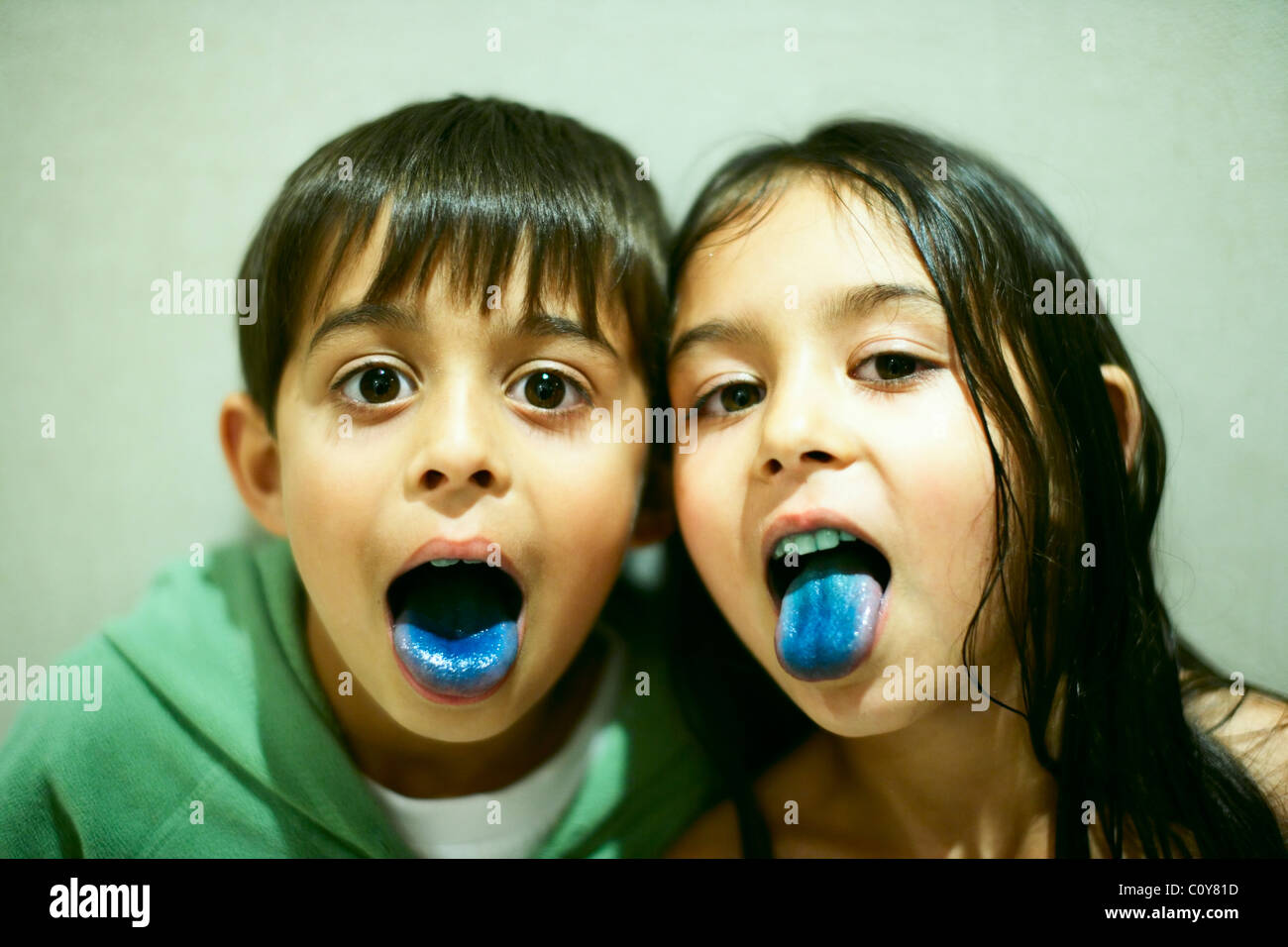 Brother and sister get blue tongues from lollies Stock Photo