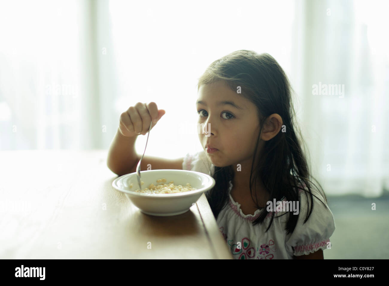 Six year old girl with bowl of breakfast cereal Stock Photo