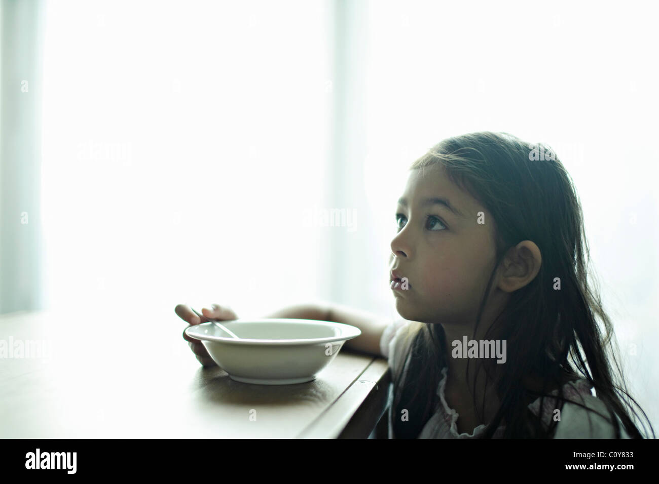 Six year old girl with bowl of breakfast cereal Stock Photo