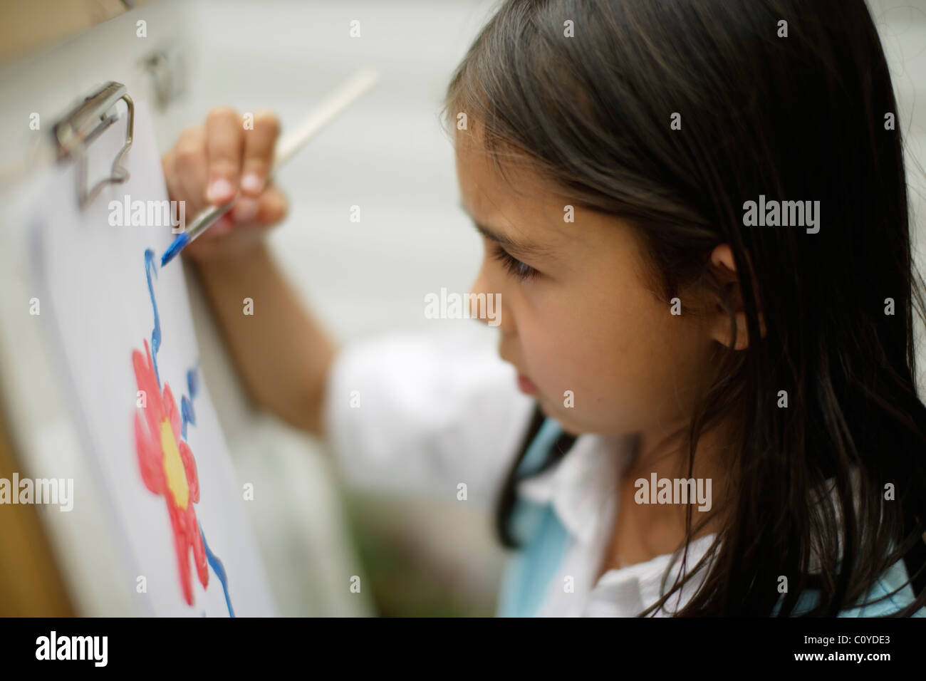 Girl painting on easel. Stock Photo