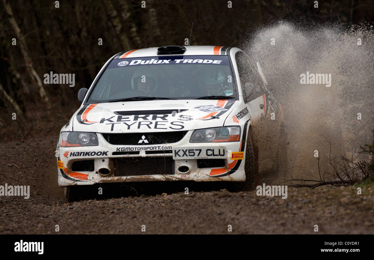Mitsubishi Evo racing at the Sunseeker Rally 2011 moving through large puddle creating spray Stock Photo