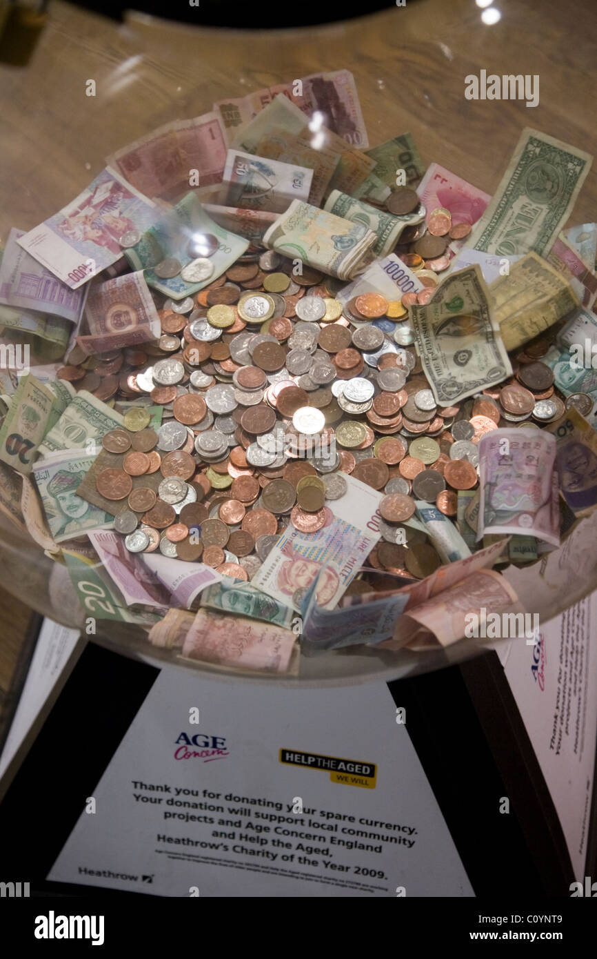 Box collection / collecting foreign currency / small change / money / cash / coins for charity at Heathrow airport, London. UK. Stock Photo