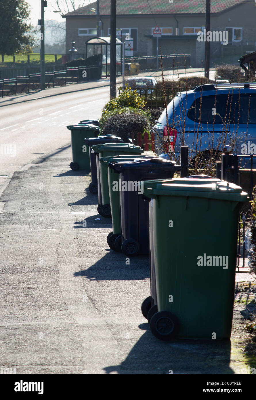 Line of wheelie bins waiting to be emptied on english street. Stock Photo