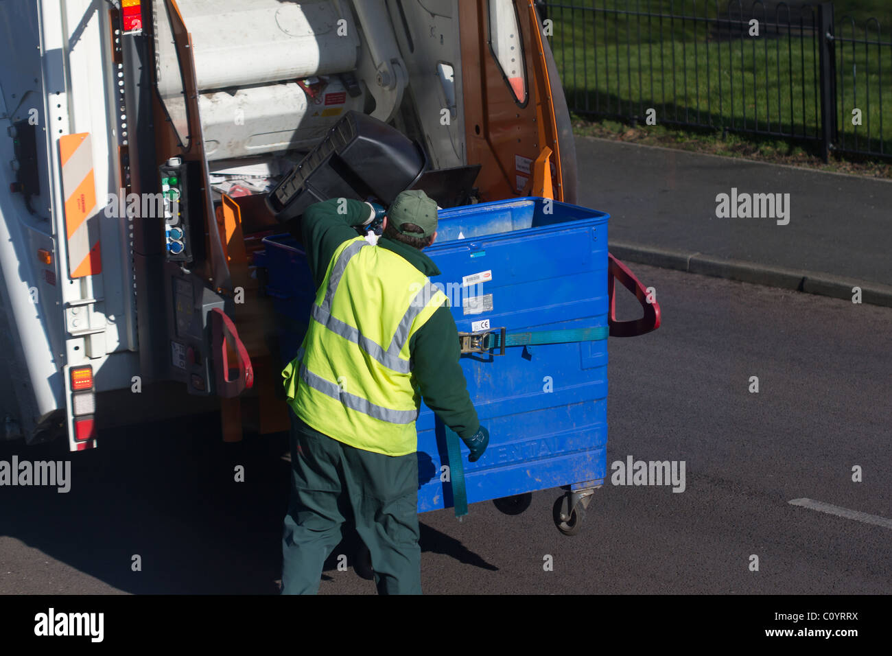 Council dustman collecting household recycling and emptying into bin wagon. Stock Photo