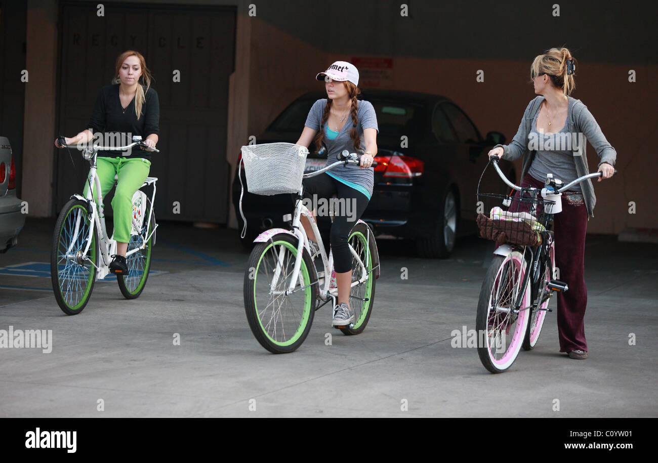 Miley Cyrus riding a bicycle with her sister and mother Leticia 'Tish