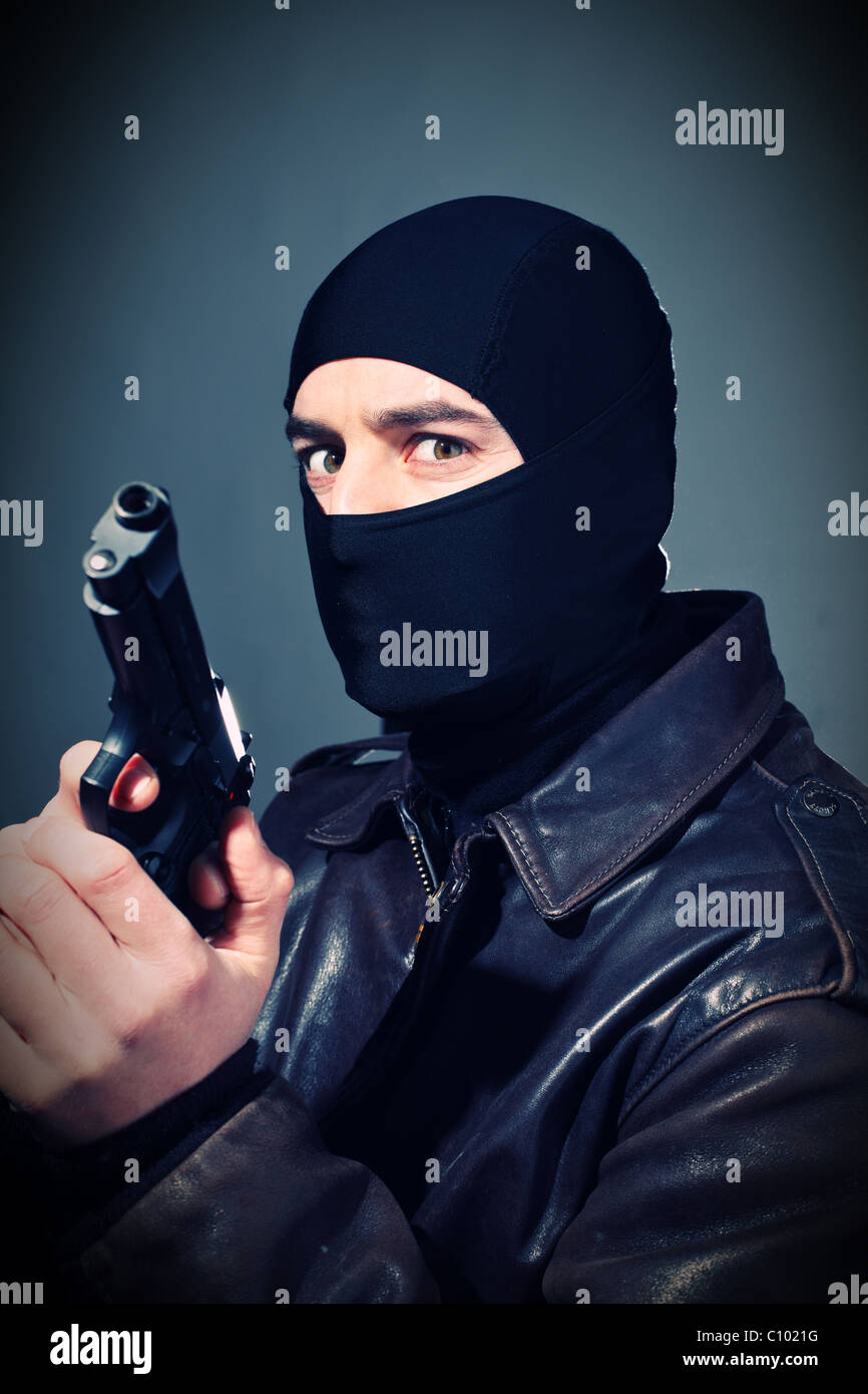 fine closeup portrait of criminal holding pistol Stock Photo
