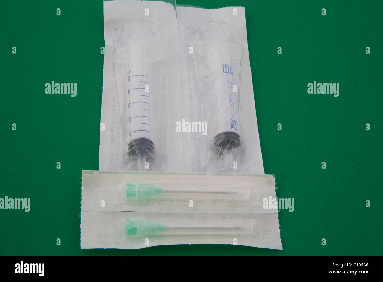 Close up sterile packs of two syringes and needles from a medical