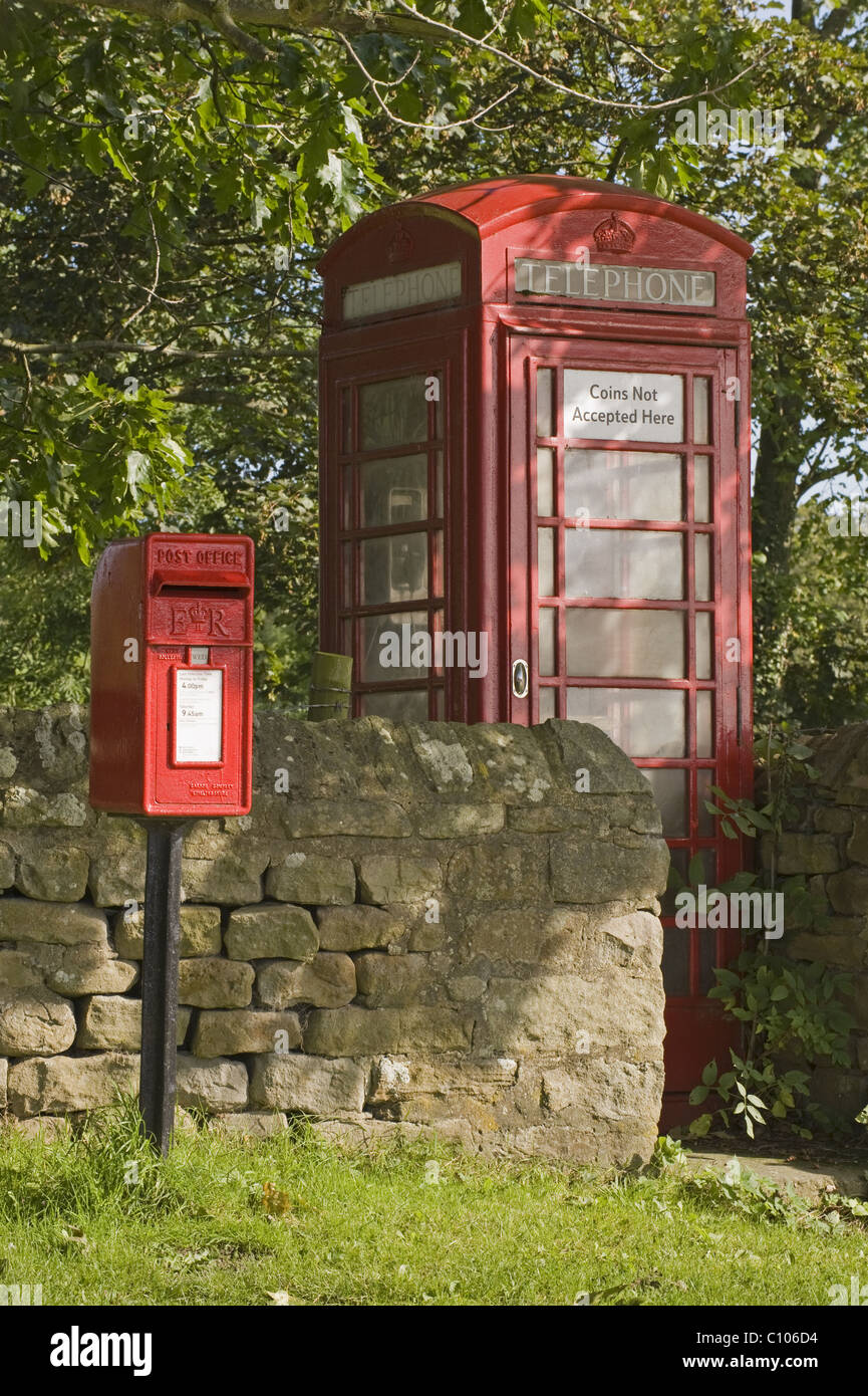 Street furniture red post box & iconic historic K6 telephone box by drystone wall in scenic