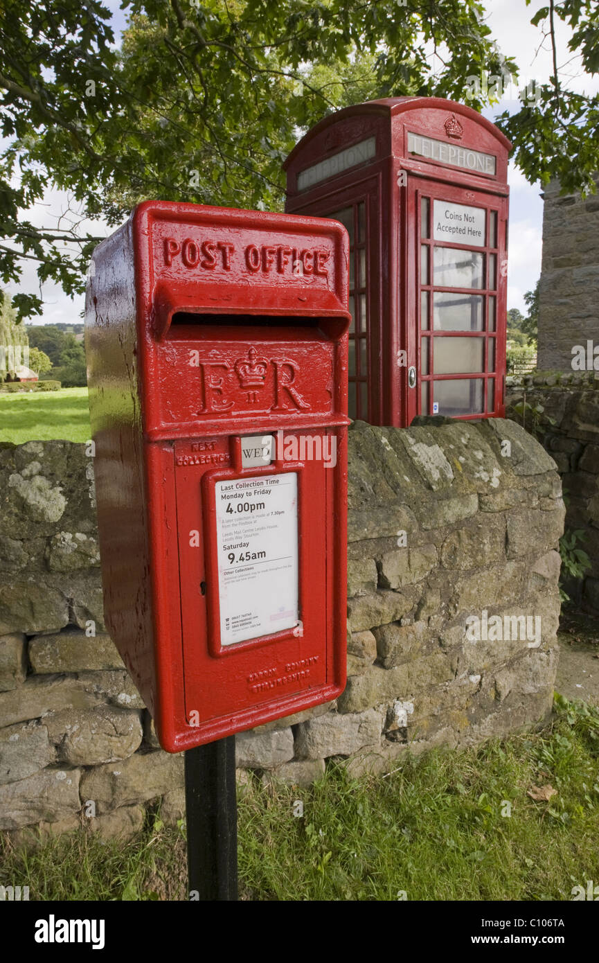 Street furniture red post box & iconic historic K6 telephone box by drystone wall in scenic