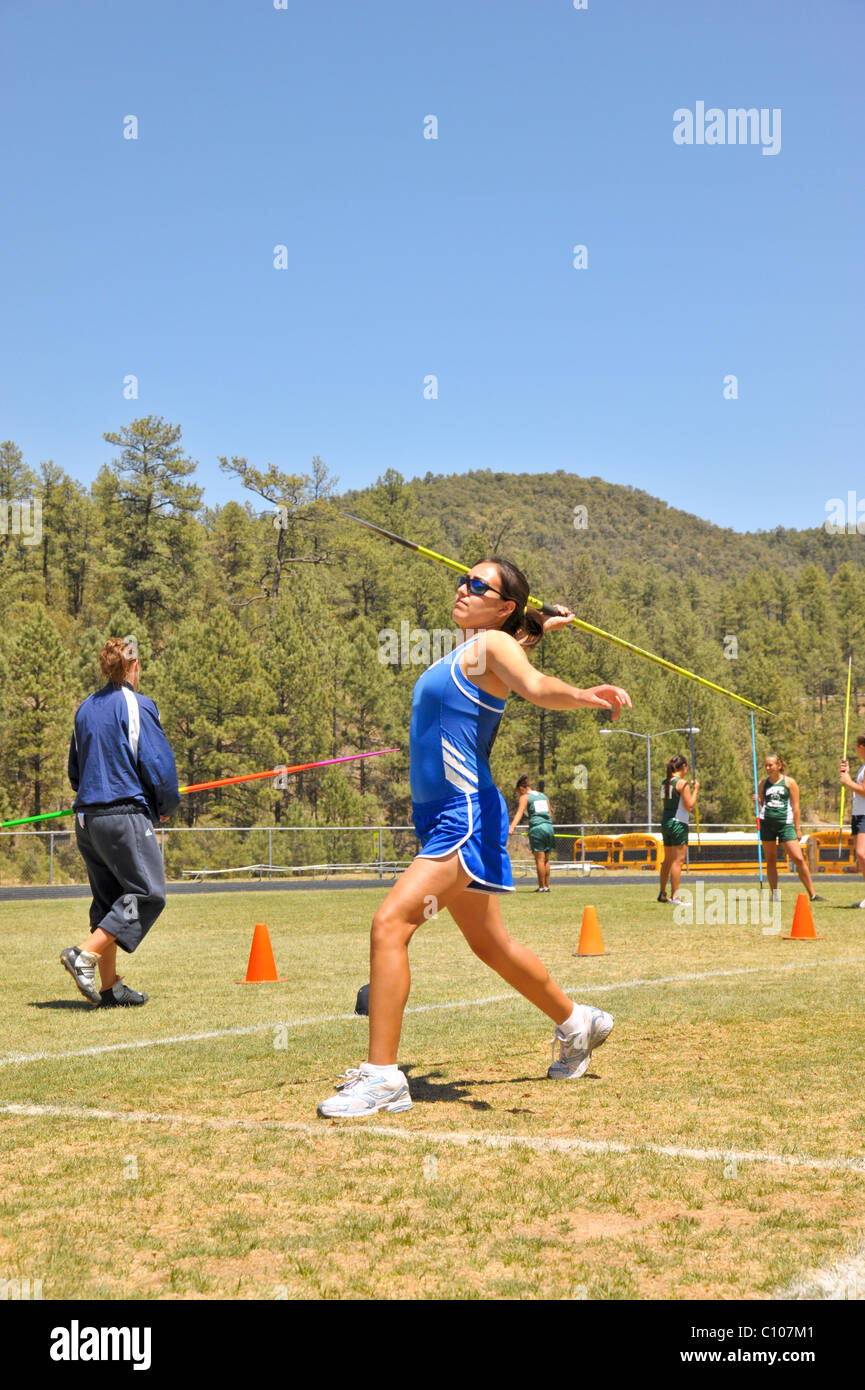Teenage high school girl athlete participates in the javelin throw