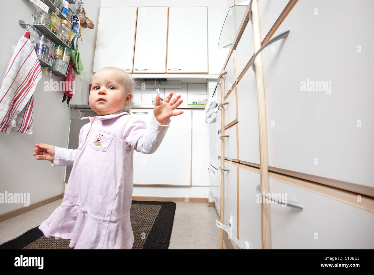 toddler exploring in safe kitchen Stock Photo Alamy
