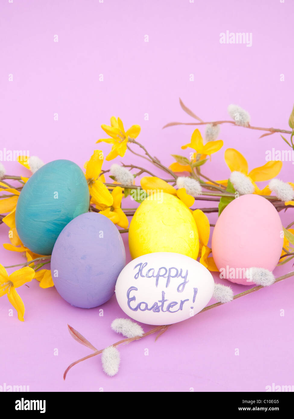 Closeup image of hand painted Easter eggs and spring flowers on purple ...