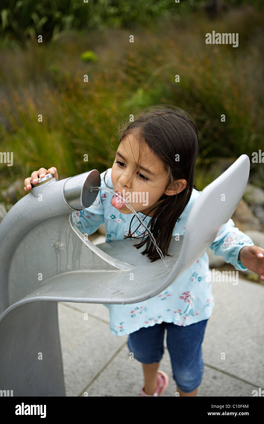 Girl drinks from water fountain Stock Photo