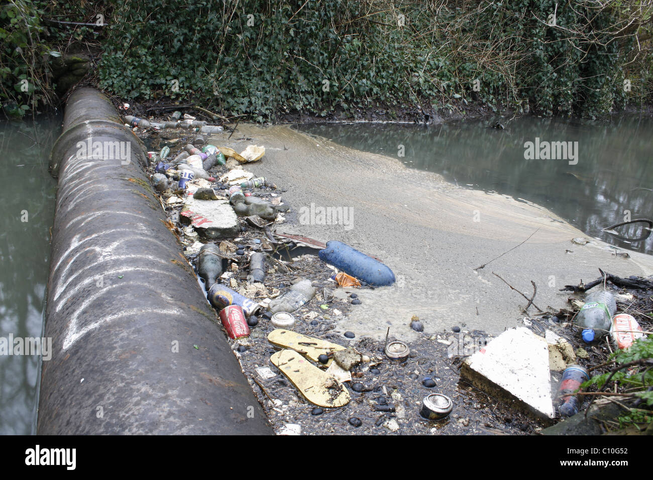 rubbish against sewage pipe in river Ryton, Worksop, Notts Stock Photo
