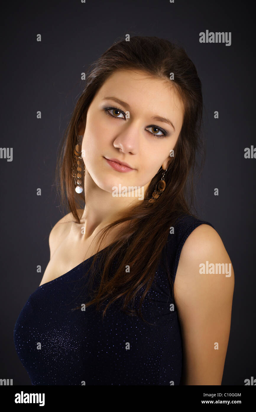 Portrait of a beautiful young woman in evening dress on black ...