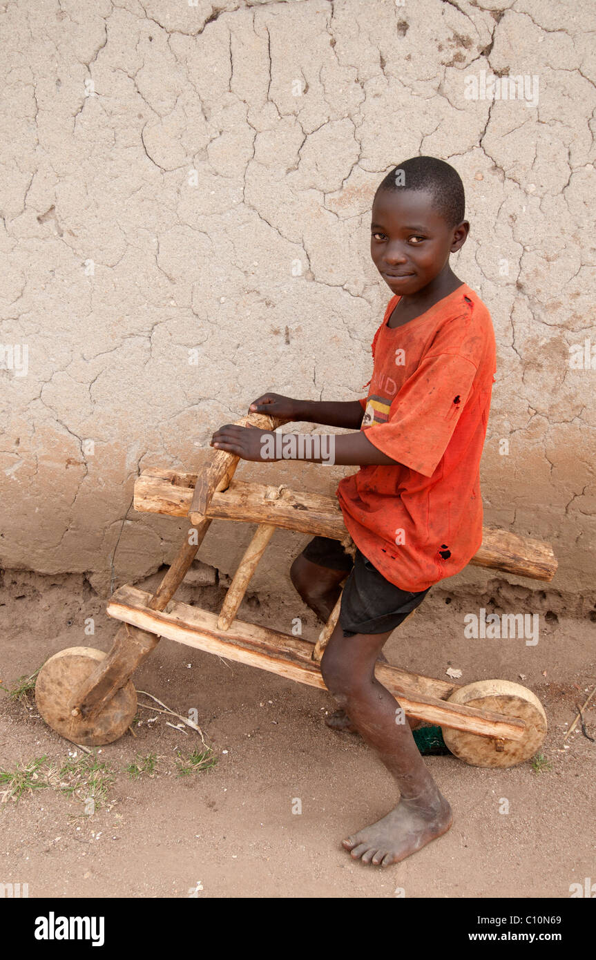 Uganda 2011. Boy playing on a home-made bike made from wood. Stock Photo