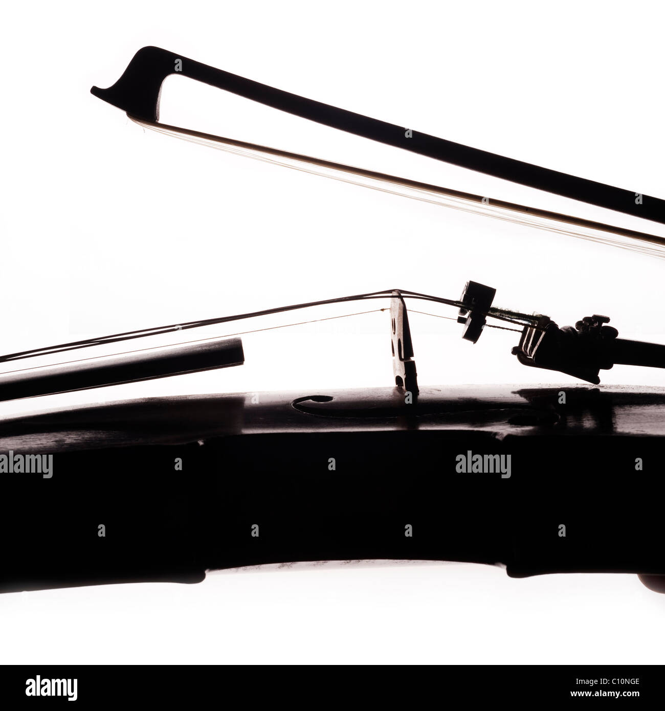 Side view of bridge and waist of a wood violin fitted with a mute, with