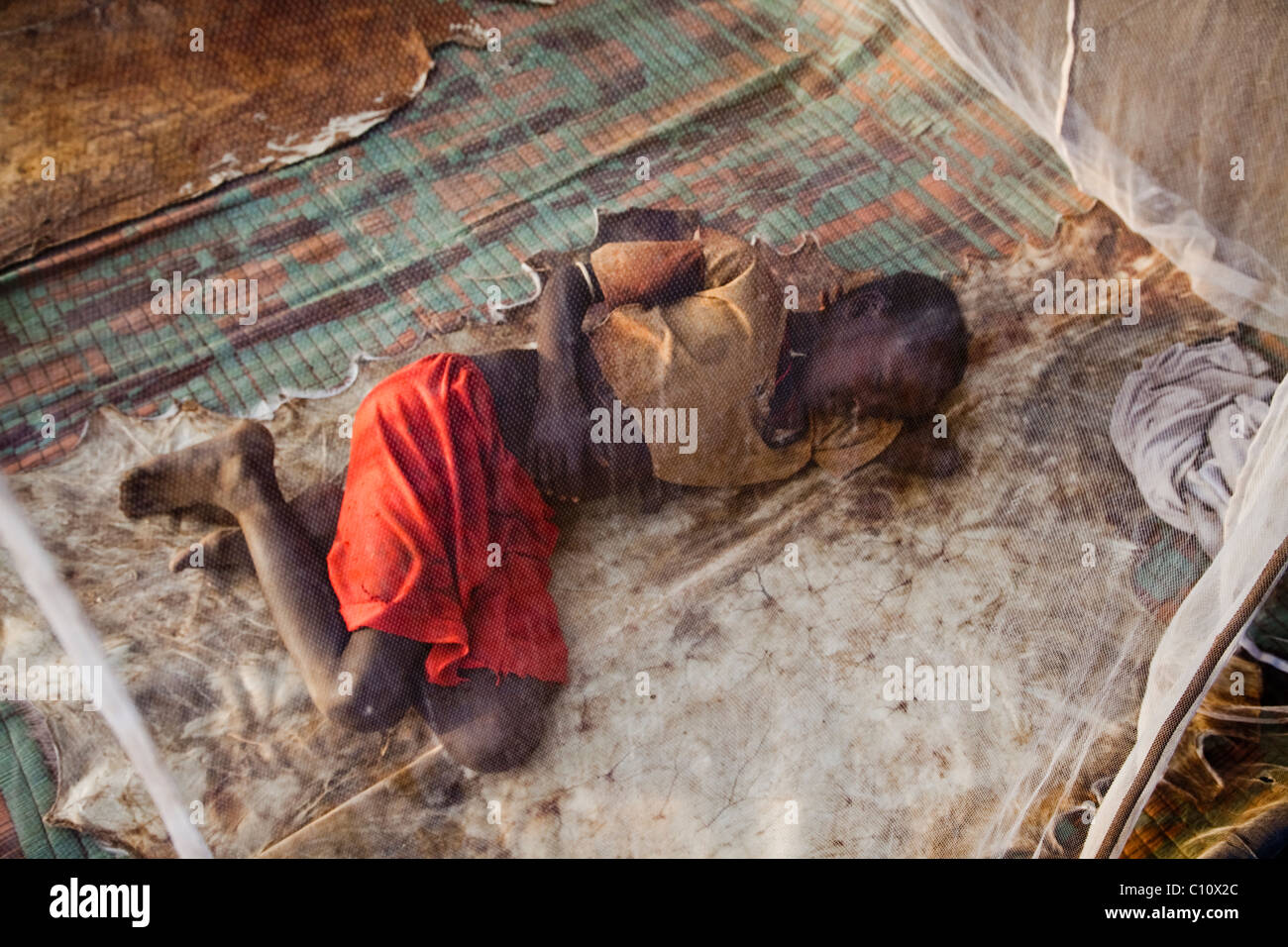 Tsemai girl sleeps under a mosquito net in Ethiopia Stock Photo