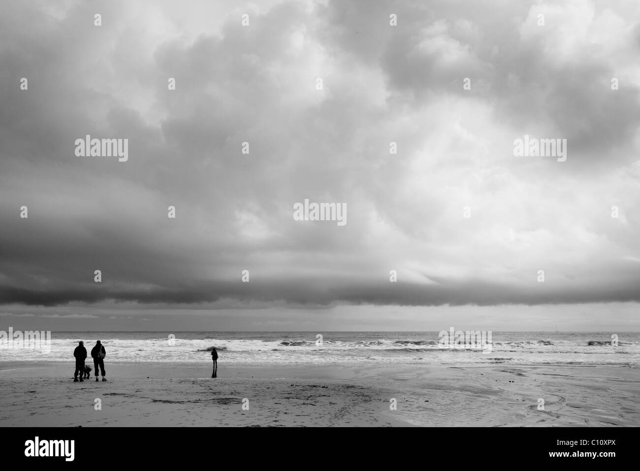 Wintry seaside scene with people walking on the beach in South Devon Stock Photo