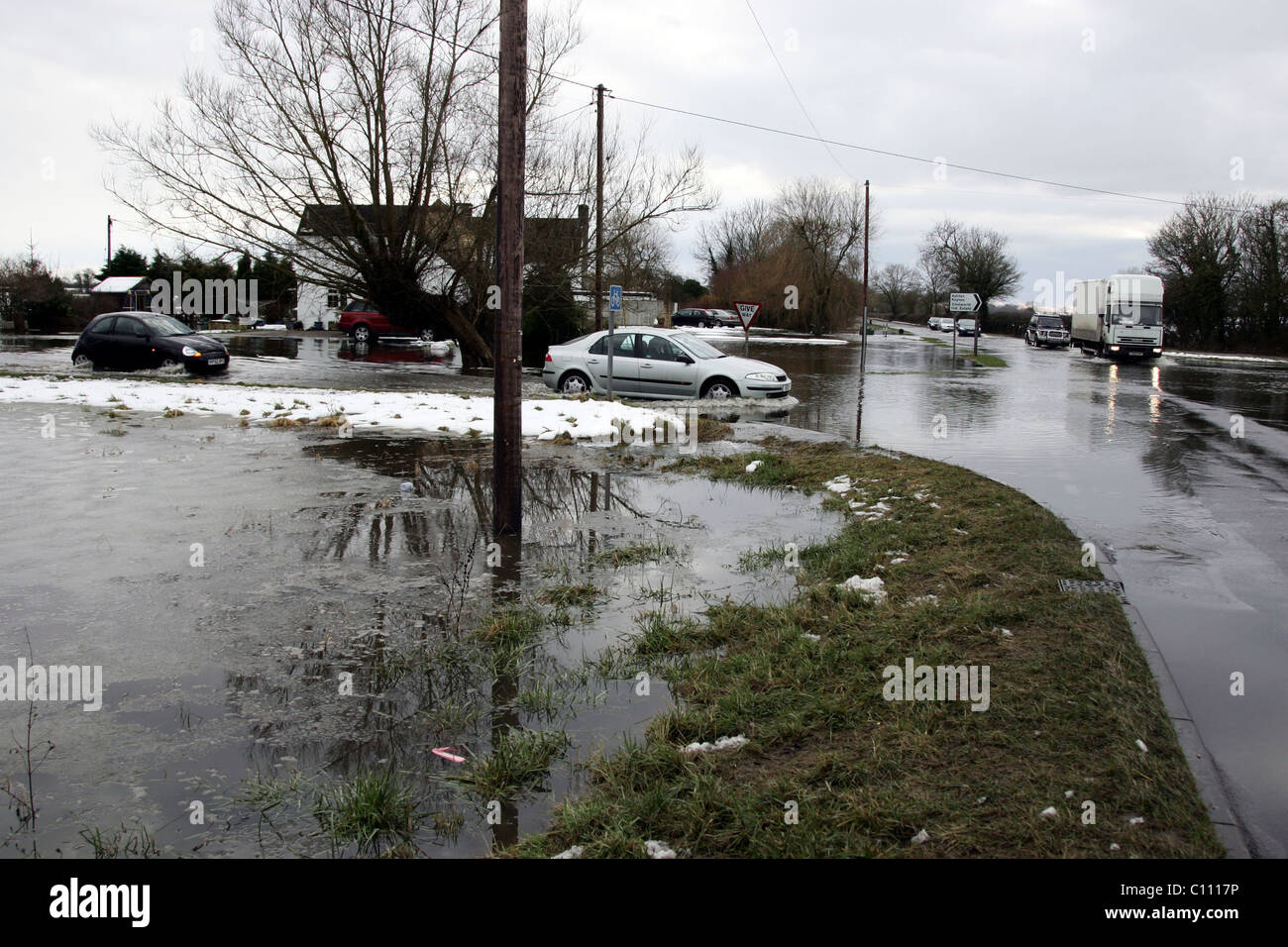 Motorists pass through floods caused by melting snow and ice on the