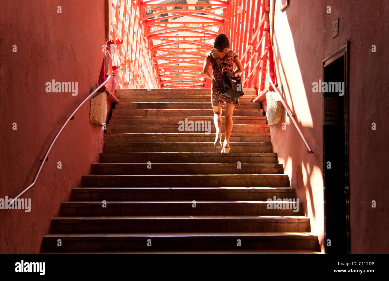 Girl walking up the stairs of a red bridge Stock Photo