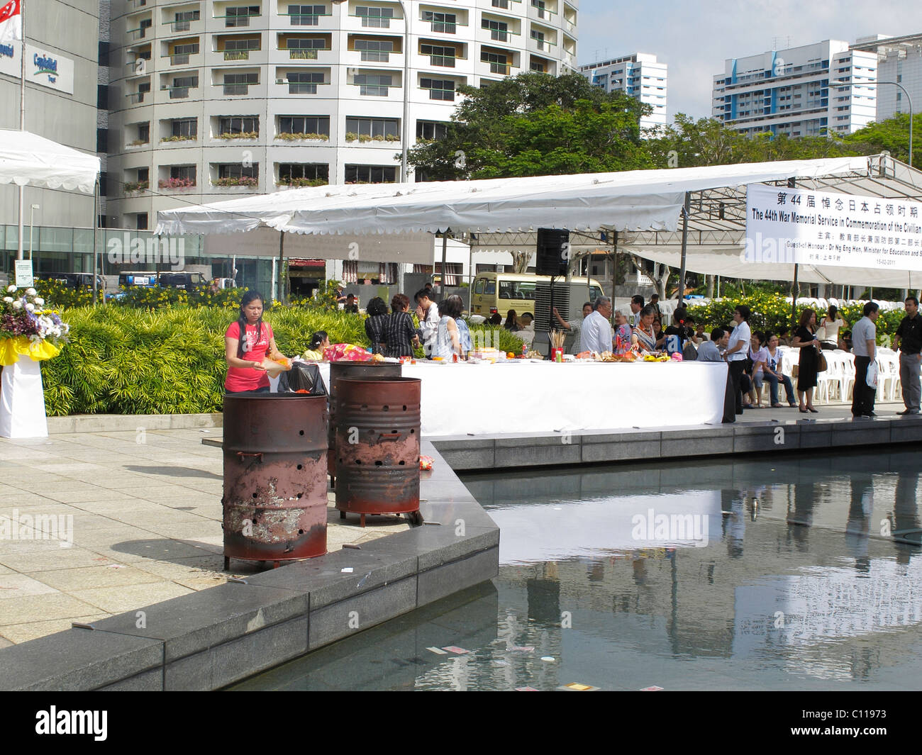 Food set out for the dead by Buddhists at  The Memorial to the Victims of the Japanese Occupation in Singapore and burning money Stock Photo