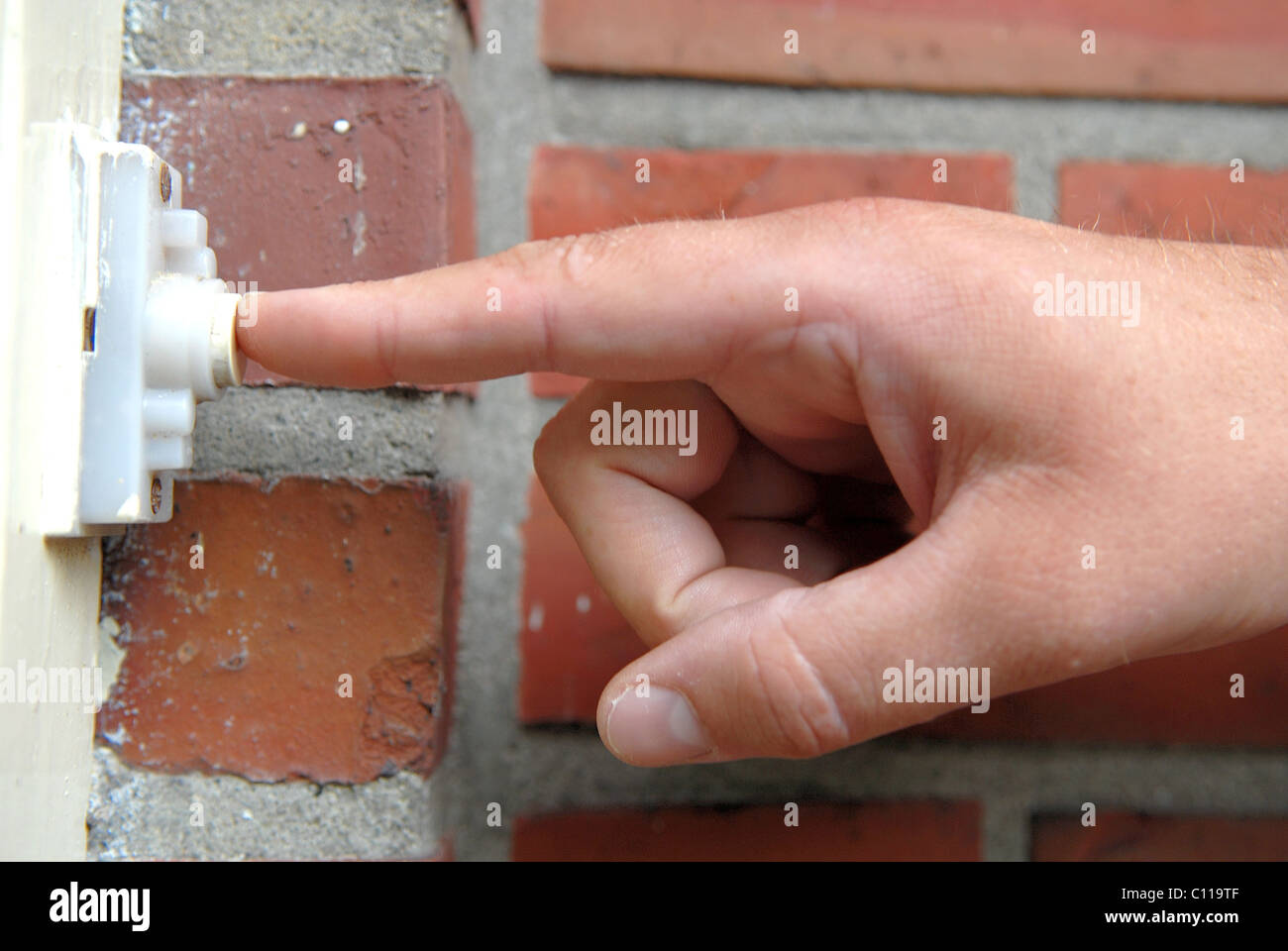 Hand ringing doorbell Stock Photo