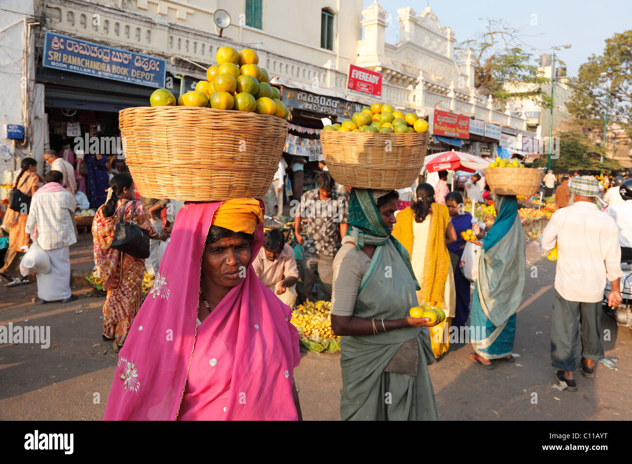Women selling oranges and carrying baskets on head, Devaraja Market