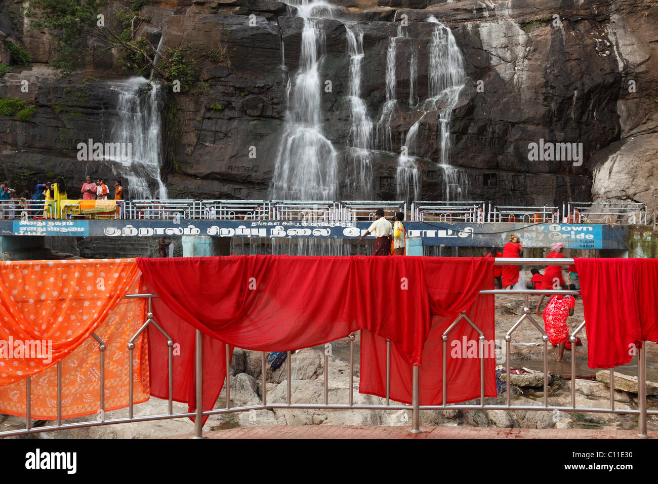 Red cloths hanging out to dry on a railing, Kutralam waterfalls, Peraruvi, Main Falls, Kuttralam, Kuttalam, Courtallam Stock Photo