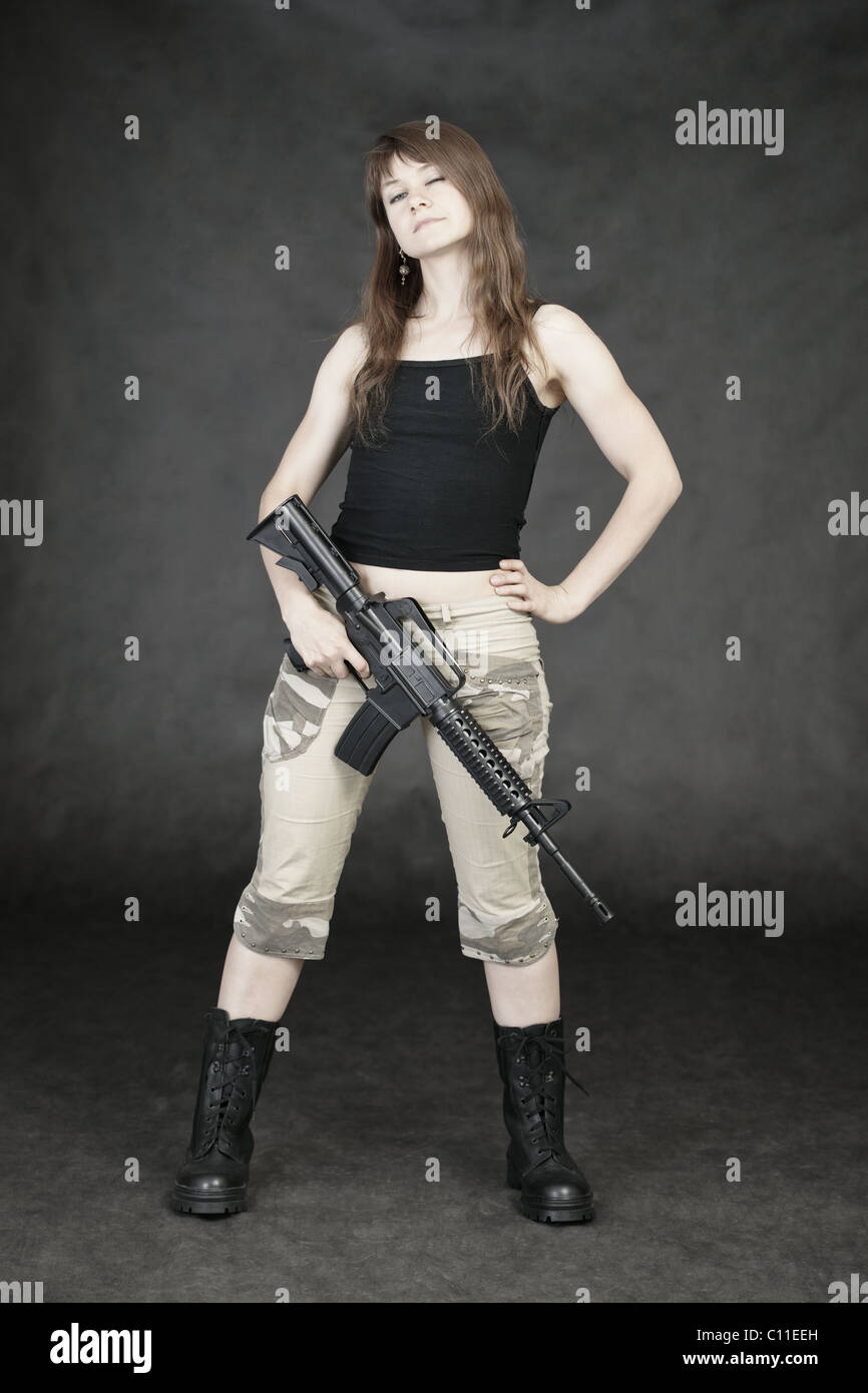 Woman armed with American rifle standing on black Stock Photo