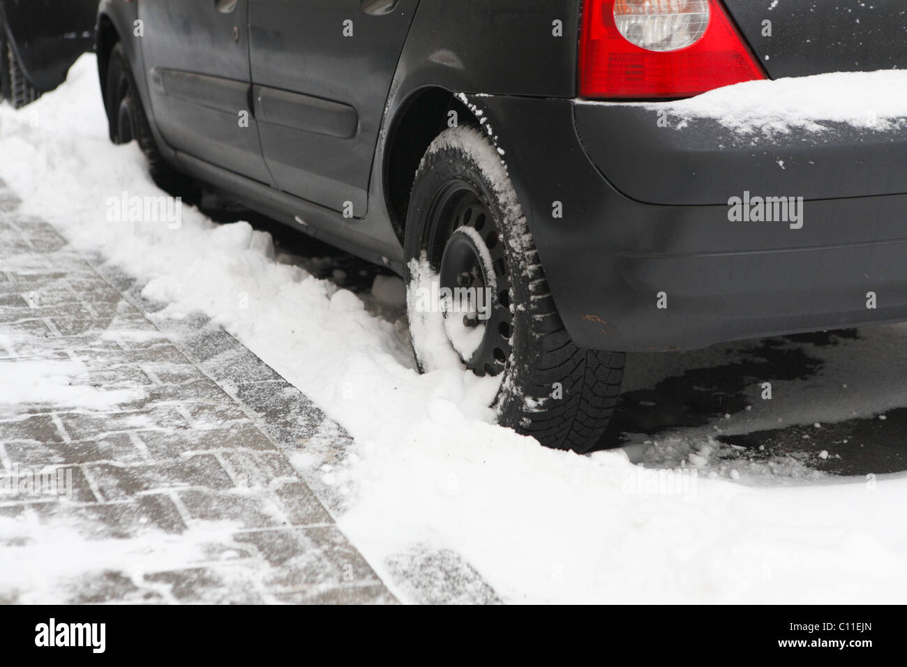 Left back tire of a black car stuck in snow, winter, Germany Stock
