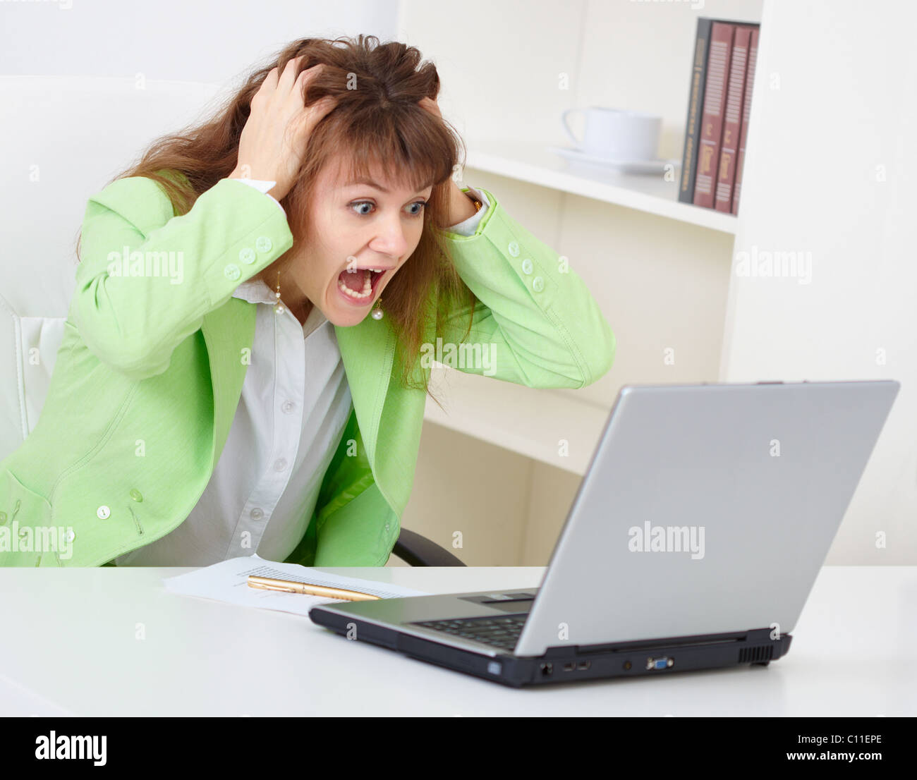 Enraged woman reads news in Internet Stock Photo