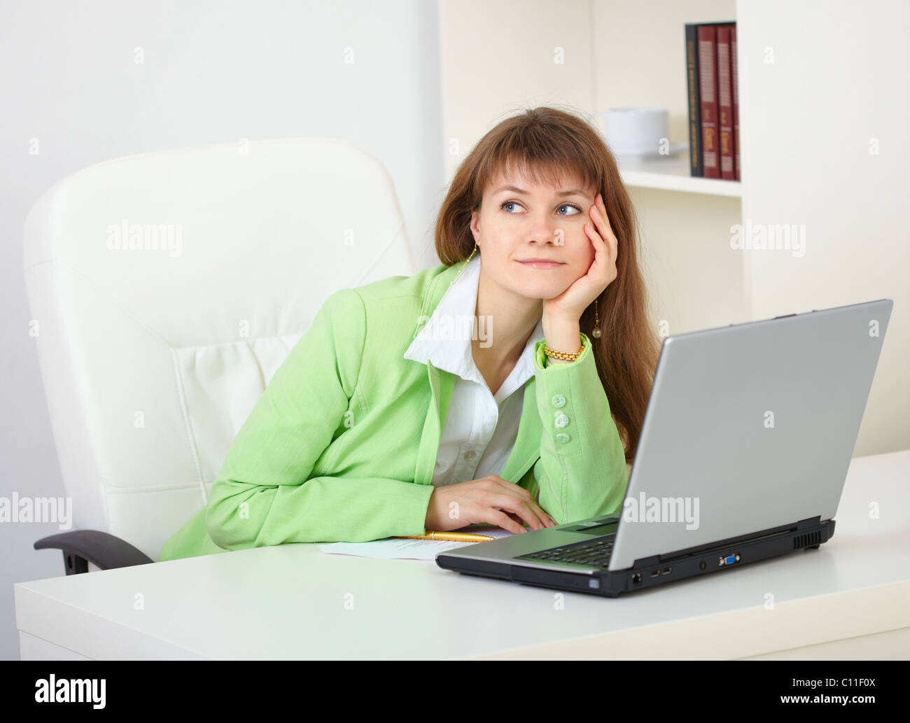 Girl dreams working with laptop at office Stock Photo