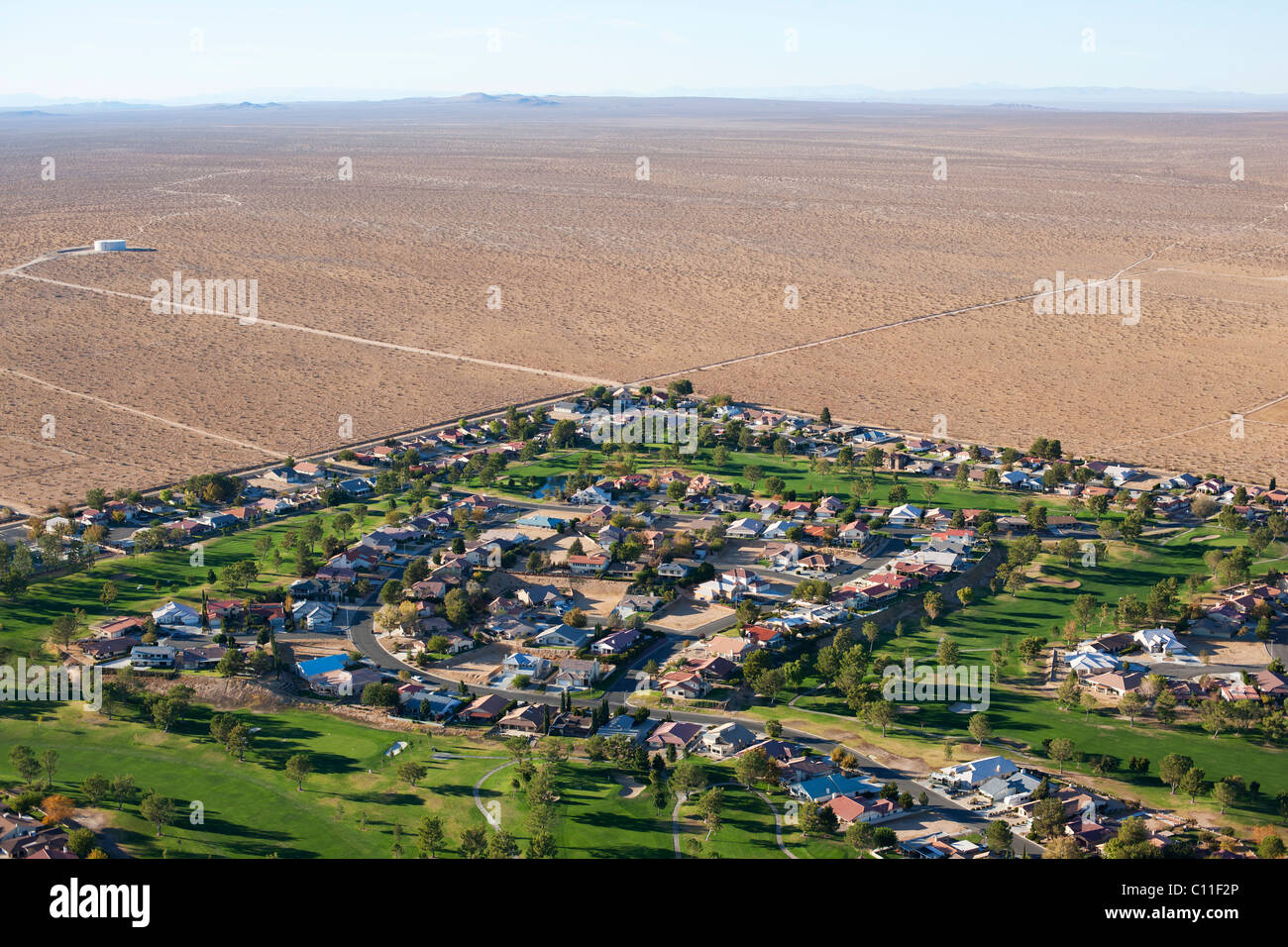 AERIAL VIEW. Housing development in the harsh Mojave Desert. Unincorporated community of Helendale, San Bernardino County, California, USA. Stock Photo