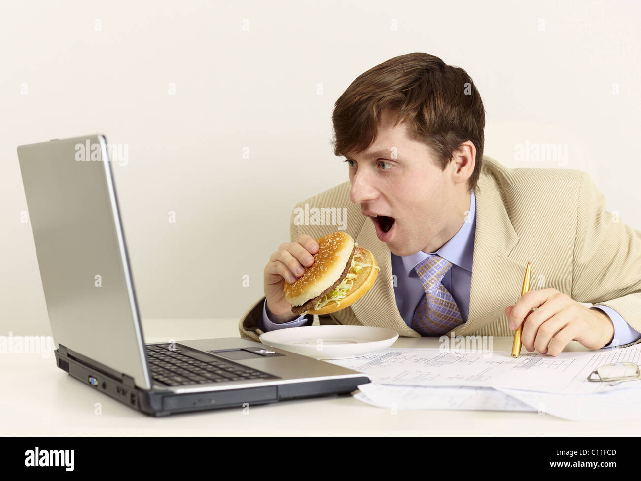 Young businessman is going to eat sandwich Stock Photo