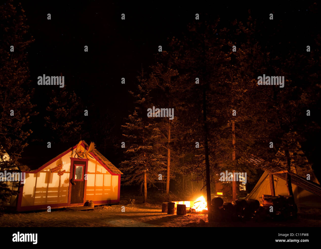 Illuminated wall tent, cabin, camp fire, near Whitehorse, Yukon