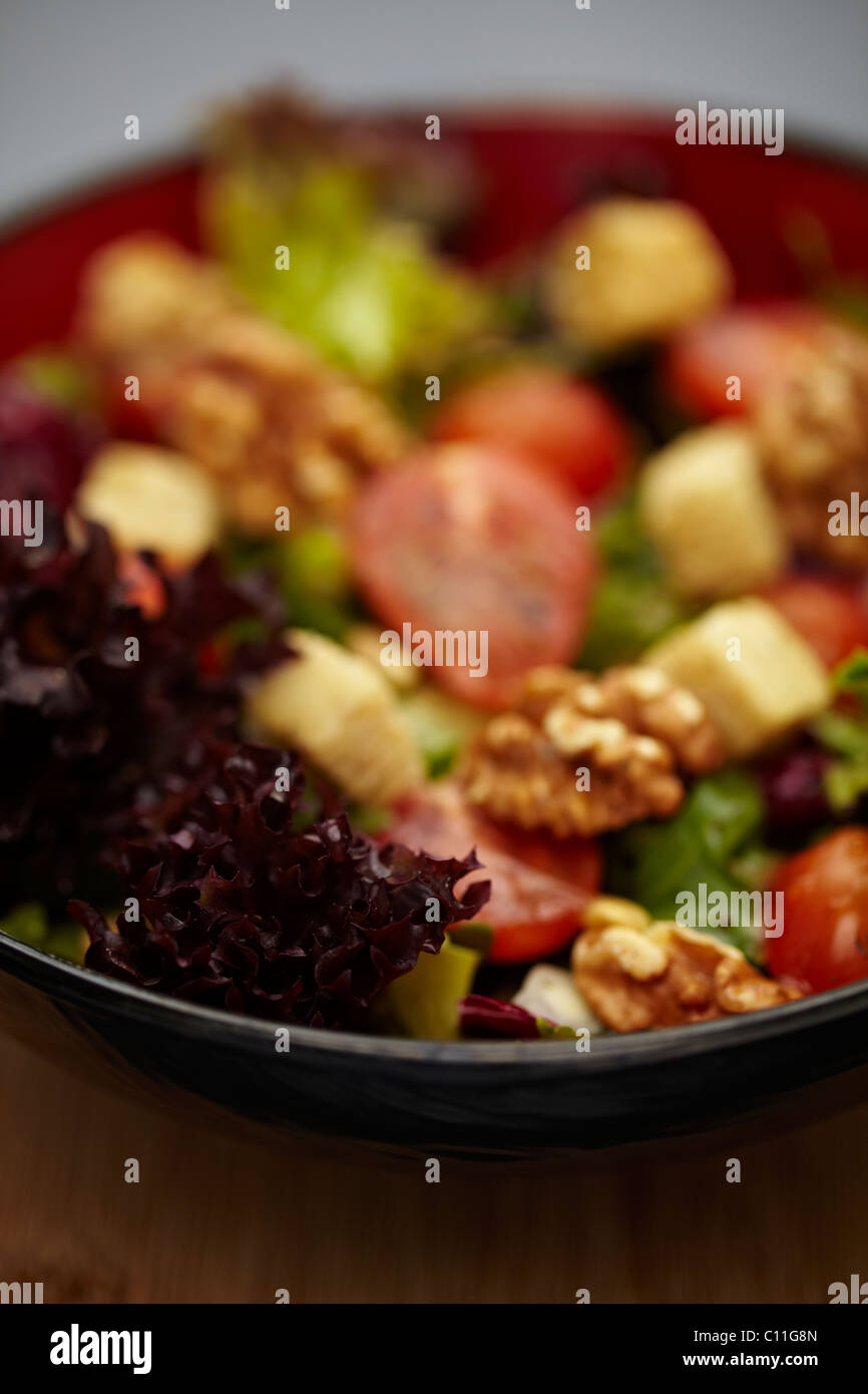 A healthy leafy salad with tomatoes, nuts, onions and croutons Stock Photo