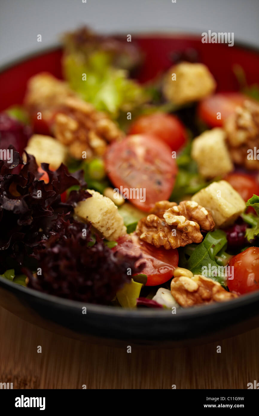 A healthy leafy salad with tomatoes, nuts, onions and croutons Stock Photo