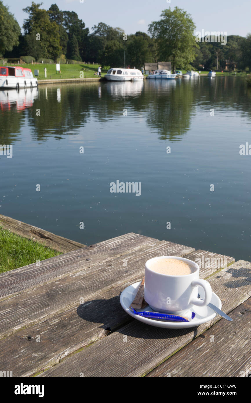 Riverside table with cup of coffee. Stock Photo