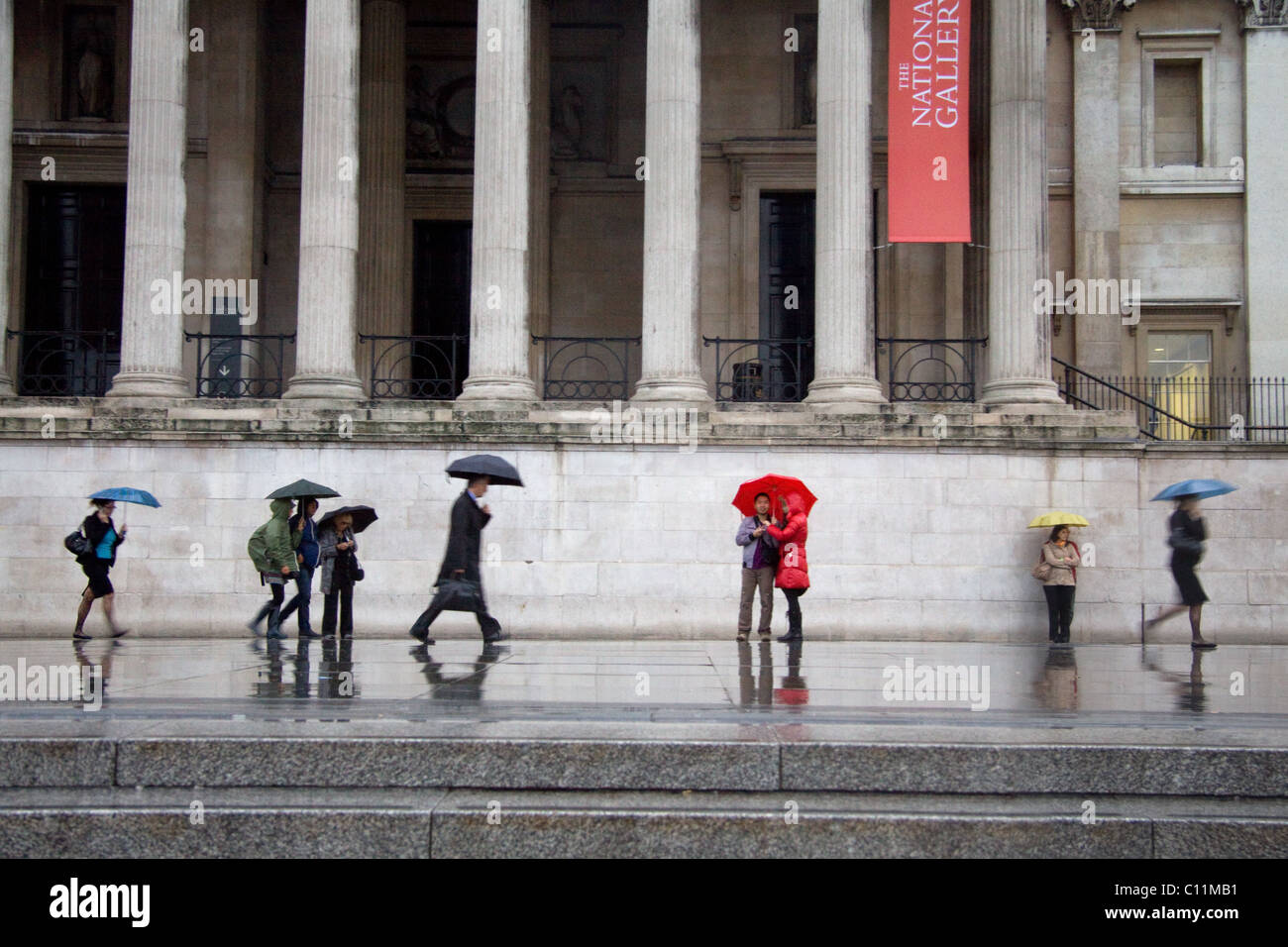 Pedestrians holding umbrellas on a rainy day outside the National Gallery, London Stock Photo