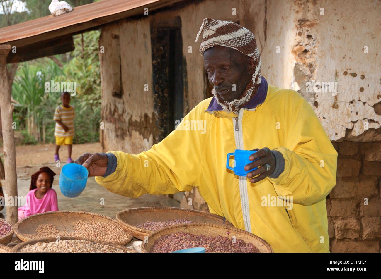 A man selling beans and grains in the town of Usa River near Arusha Tanzania Stock Photo